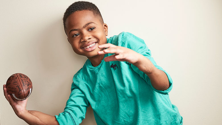 Zion holding a football Zion holding a football